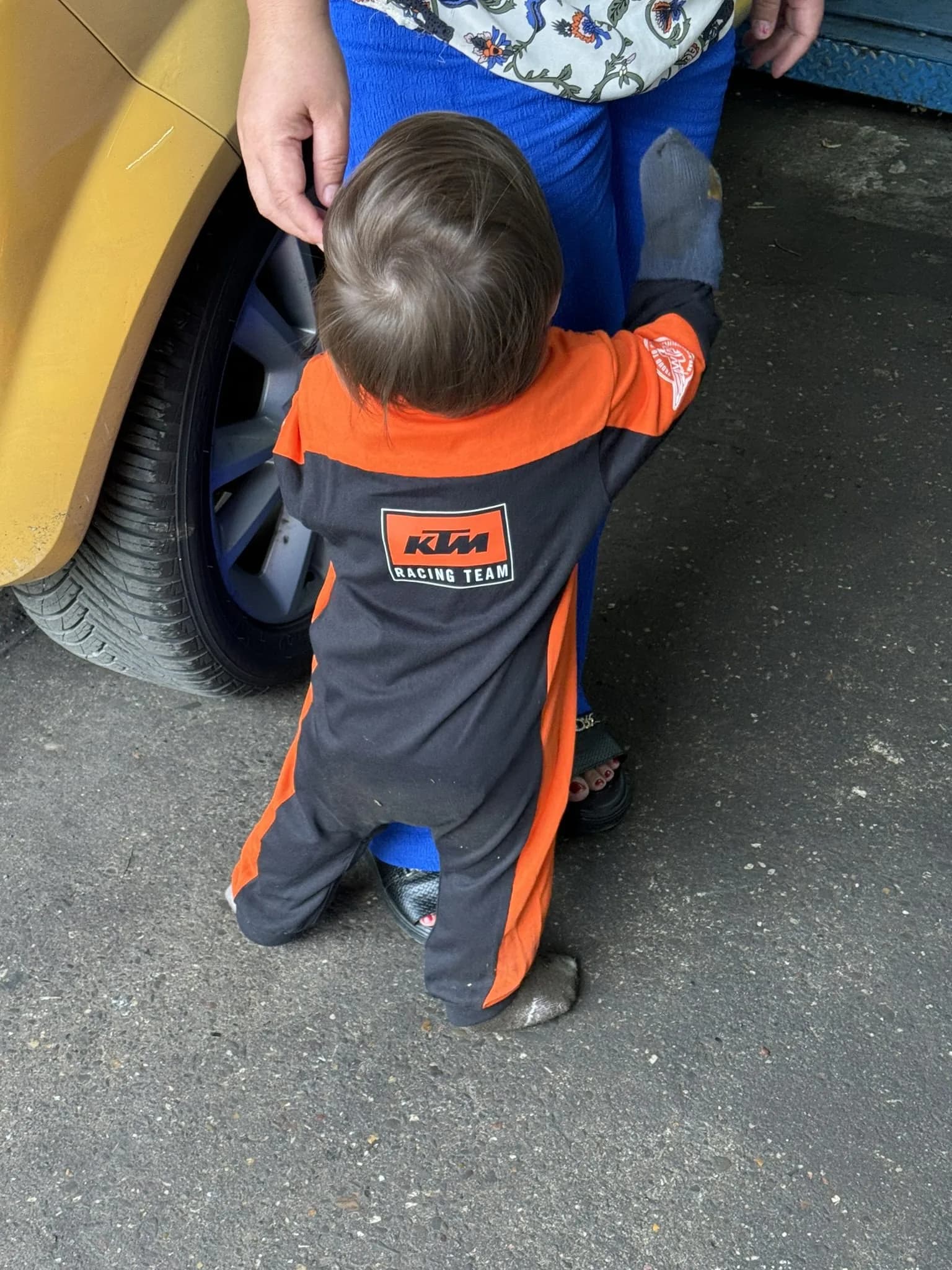 Werkstatt-Familie - Kind im KTM-Anzug am Auto