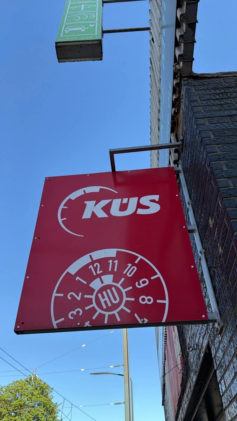 KÜS-Schild an der Werkstatt-Fassade